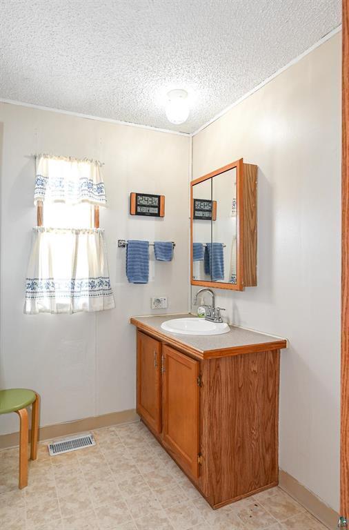 bathroom featuring a textured ceiling and vanity