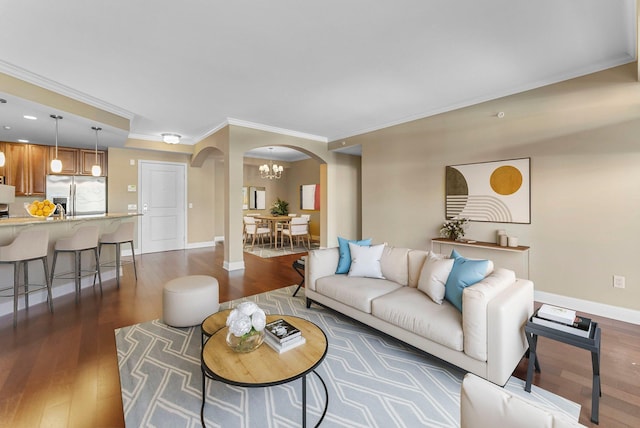 living area with arched walkways, dark wood-type flooring, baseboards, and crown molding