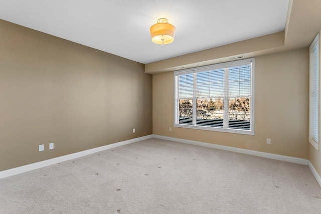 empty room with baseboards and light colored carpet