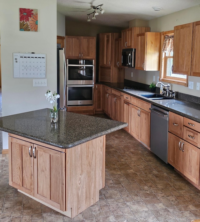 kitchen featuring stainless steel appliances, a center island, brown cabinets, and a sink