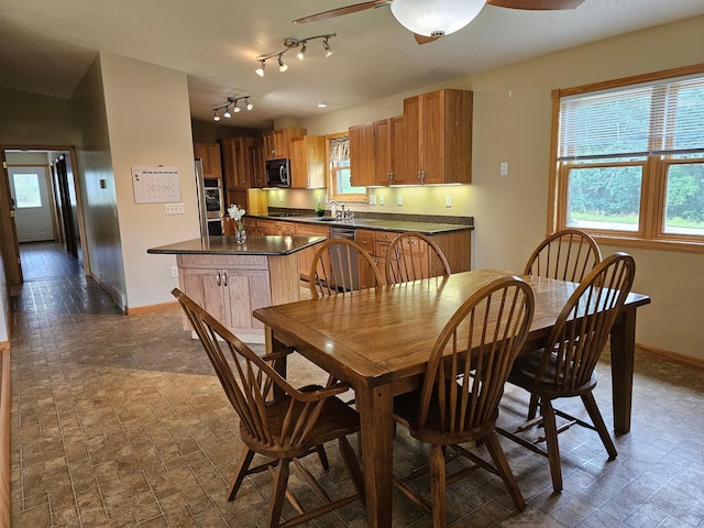 dining space with ceiling fan and baseboards