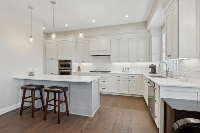 kitchen with stainless steel appliances, custom range hood, a sink, and tasteful backsplash