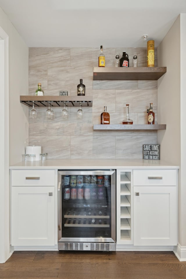 bar with a dry bar, beverage cooler, and wood finished floors