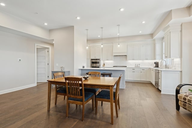 dining room with baseboards, wood finished floors, and recessed lighting