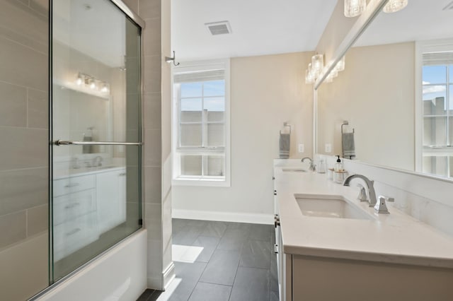 full bathroom with enclosed tub / shower combo, double vanity, a sink, and visible vents