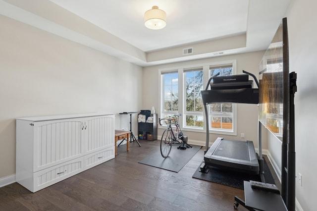 workout room with baseboards, visible vents, and wood finished floors