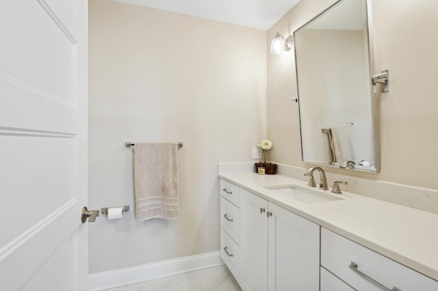 bathroom with marble finish floor, baseboards, and vanity