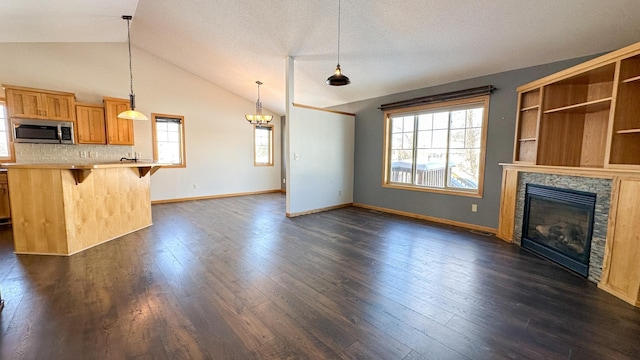 unfurnished living room featuring a fireplace, dark wood-type flooring, a textured ceiling, and lofted ceiling