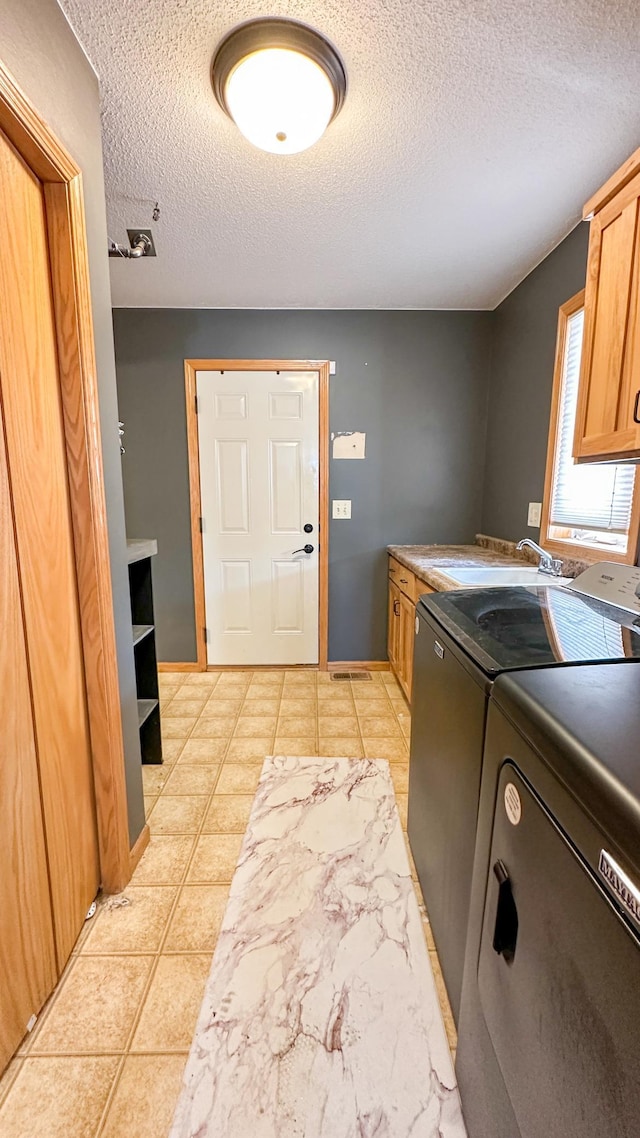 washroom featuring cabinets, light tile patterned floors, sink, and separate washer and dryer