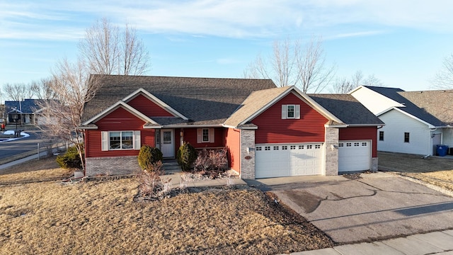 ranch-style home with a garage, driveway, a shingled roof, and brick siding