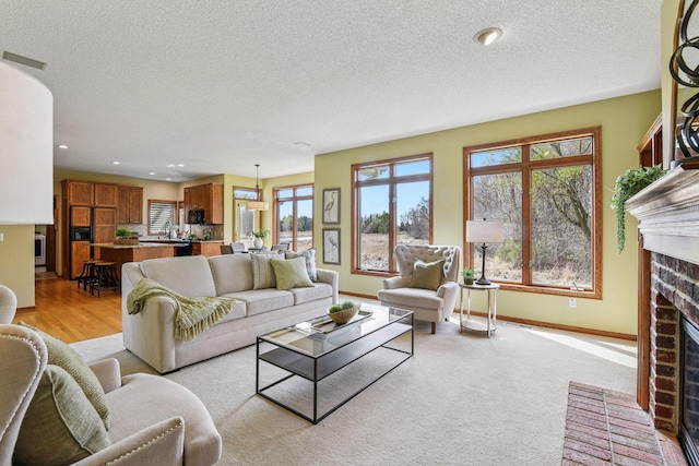 living area with a fireplace, a textured ceiling, recessed lighting, baseboards, and visible vents