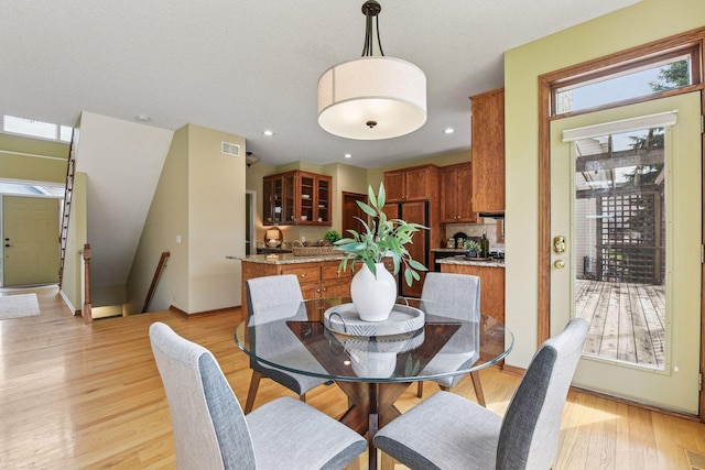 dining room featuring baseboards, light wood-type flooring, and visible vents