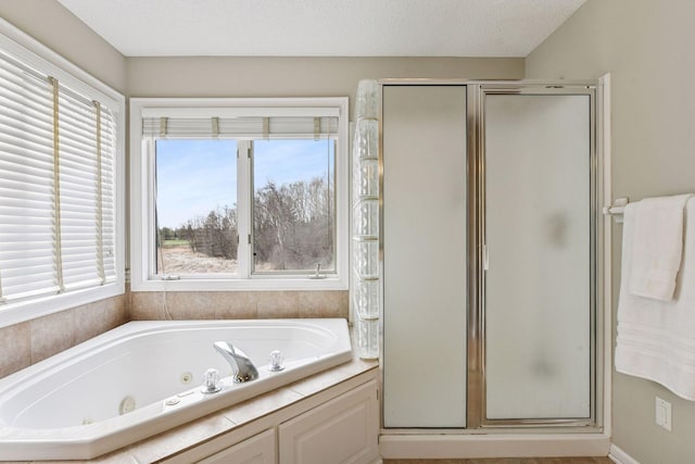 bathroom with a shower stall, a tub with jets, and a healthy amount of sunlight