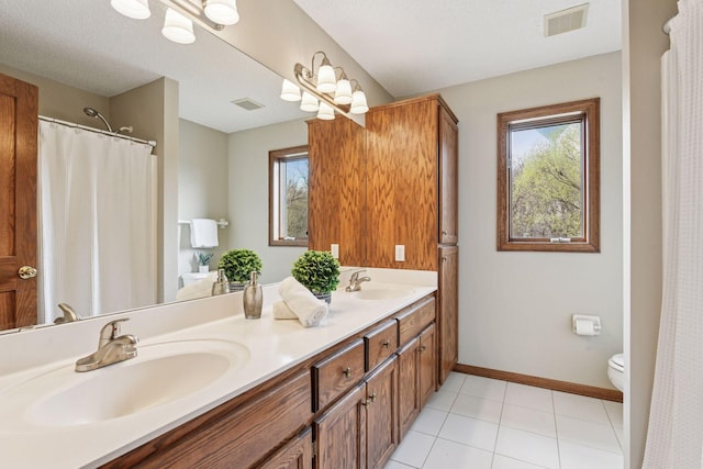 bathroom featuring visible vents, a healthy amount of sunlight, and a sink