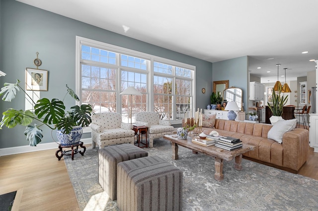 living room with recessed lighting, baseboards, and wood finished floors