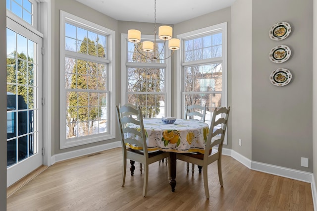 dining space with visible vents, baseboards, an inviting chandelier, and light wood finished floors