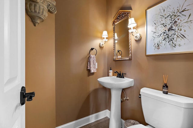 half bath with toilet and baseboards