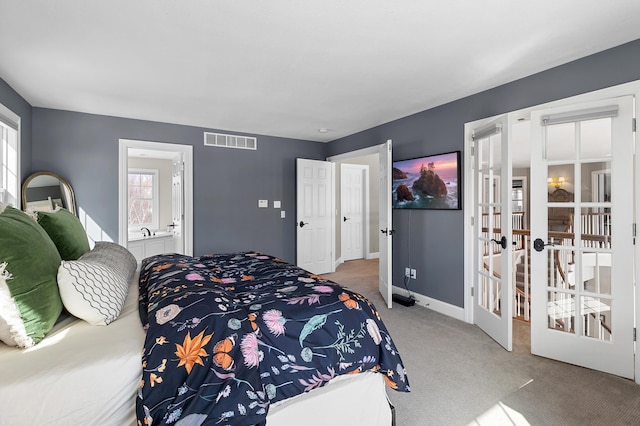 carpeted bedroom with visible vents, baseboards, connected bathroom, and french doors