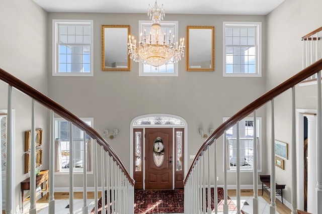 foyer with a notable chandelier, stairway, a high ceiling, and baseboards