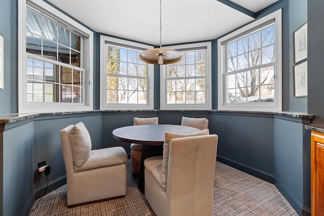 carpeted dining room with baseboards