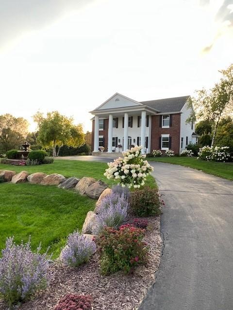 neoclassical home featuring a front yard