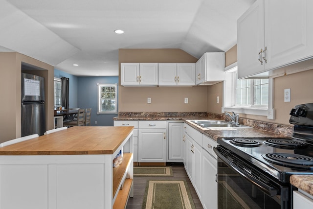 kitchen with white cabinets, a kitchen island, black electric range oven, wooden counters, and a sink