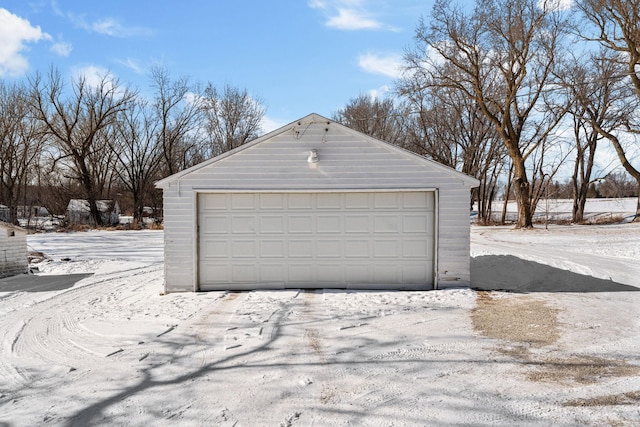 snow covered garage featuring a detached garage