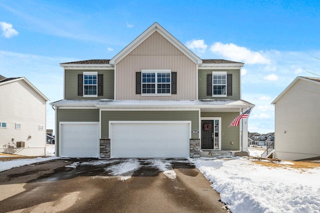 view of front facade featuring a garage, cooling unit, and driveway