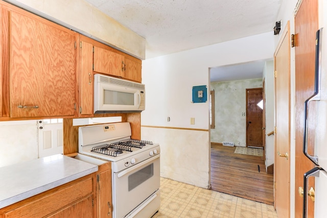 kitchen with white appliances and a textured ceiling