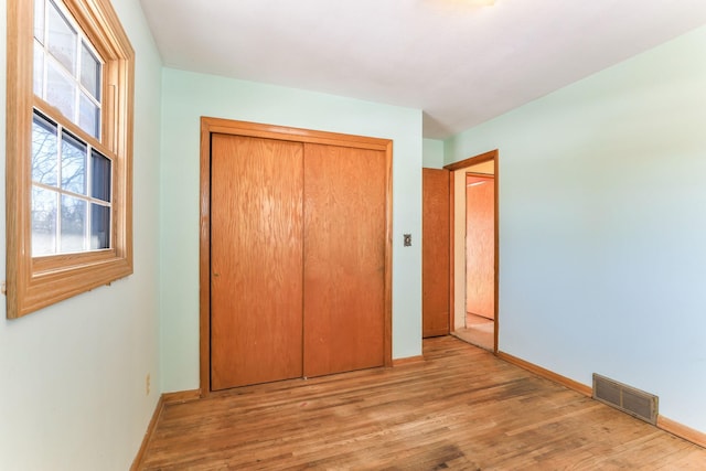 unfurnished bedroom with light hardwood / wood-style floors and a closet