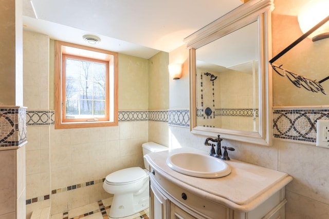 bathroom featuring tile walls, toilet, and vanity