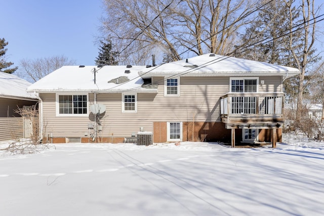 snow covered property with central air condition unit