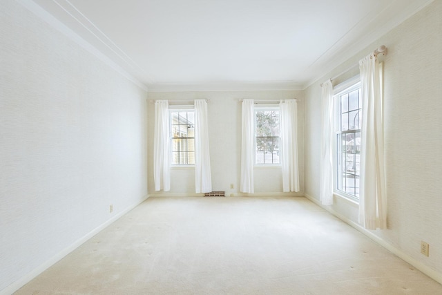 carpeted empty room featuring baseboards and crown molding