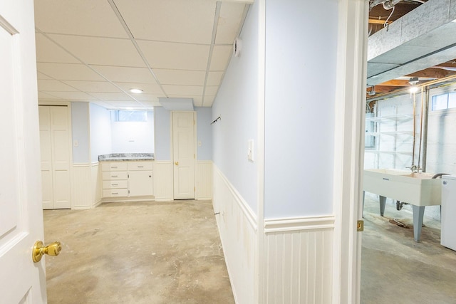 below grade area featuring a wainscoted wall and a drop ceiling