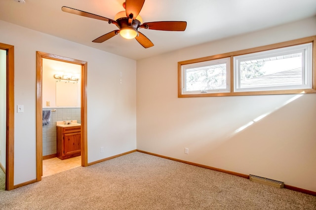 unfurnished bedroom featuring visible vents, connected bathroom, baseboards, light carpet, and a sink