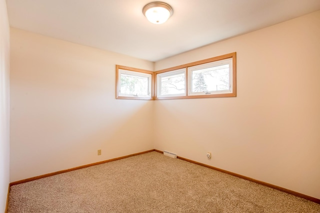 spare room with visible vents, baseboards, and carpet floors