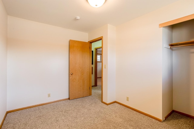 unfurnished bedroom with carpet flooring, baseboards, and a closet