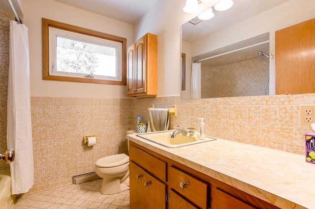 full bathroom with a wainscoted wall, toilet, a baseboard heating unit, tile walls, and vanity