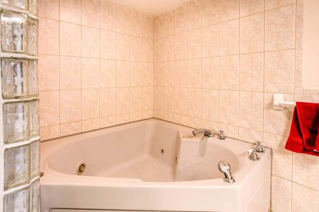 full bath featuring tile walls and a jetted tub