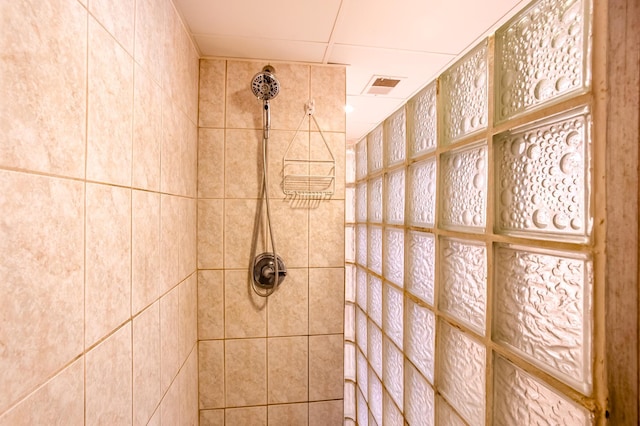 full bath with visible vents and tiled shower