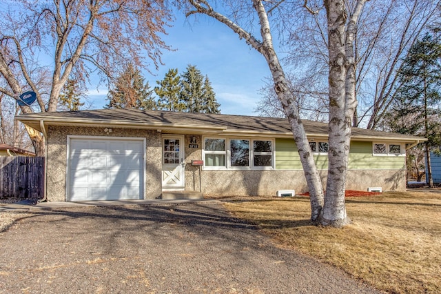 ranch-style house featuring driveway, a front lawn, an attached garage, and fence