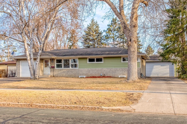 ranch-style home featuring a garage, concrete driveway, a front yard, and a shingled roof