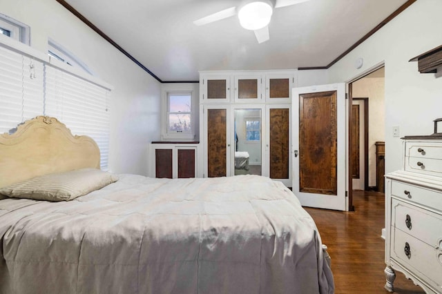 bedroom with ornamental molding, dark wood-type flooring, and a ceiling fan