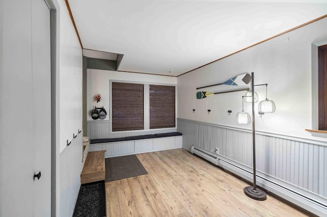 interior space featuring a baseboard heating unit, a wainscoted wall, and light wood-style flooring