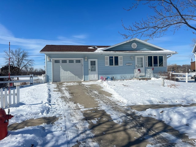 view of front of home featuring an attached garage and fence