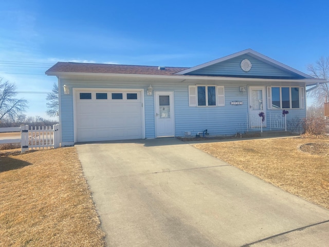 ranch-style home with concrete driveway, an attached garage, and fence