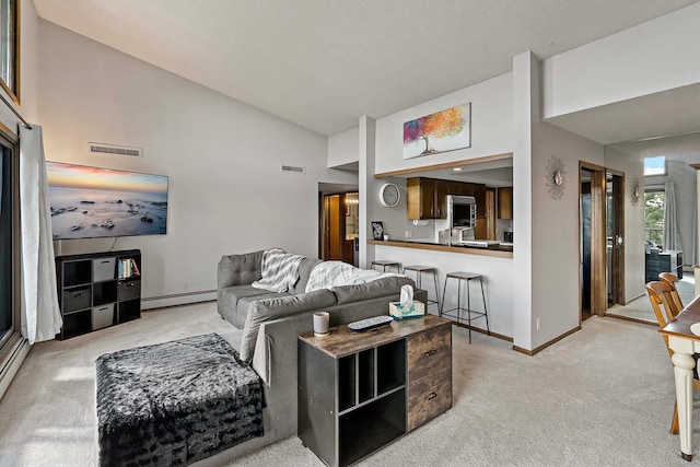 living room with a baseboard heating unit, light carpet, visible vents, and baseboards