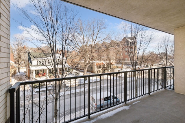 snow covered back of property with a residential view