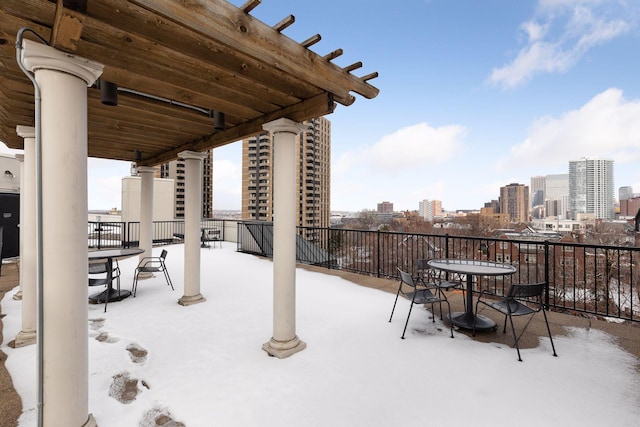 snow covered patio featuring a city view