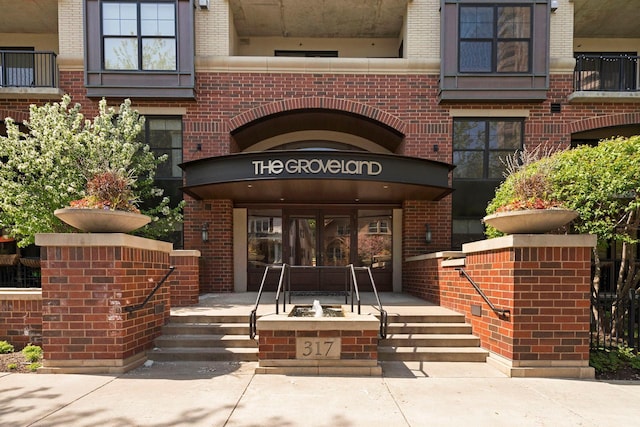 entrance to property featuring brick siding